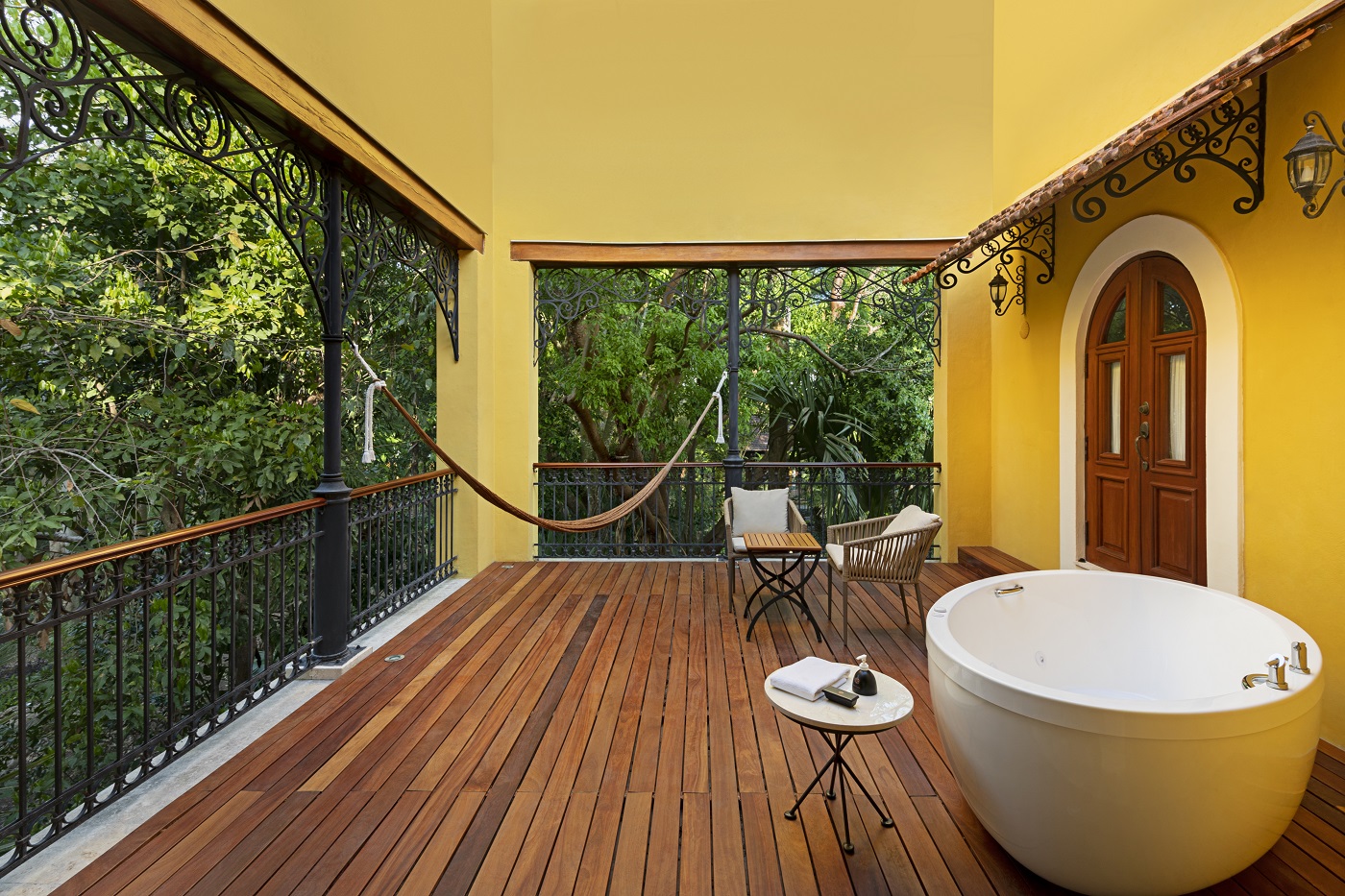 Hacienda Xcanatun, Angsana Heritage Collection patio with hammock, seating, and tub, surrounded by trees.